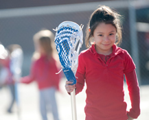 girl holding lacrosse stick